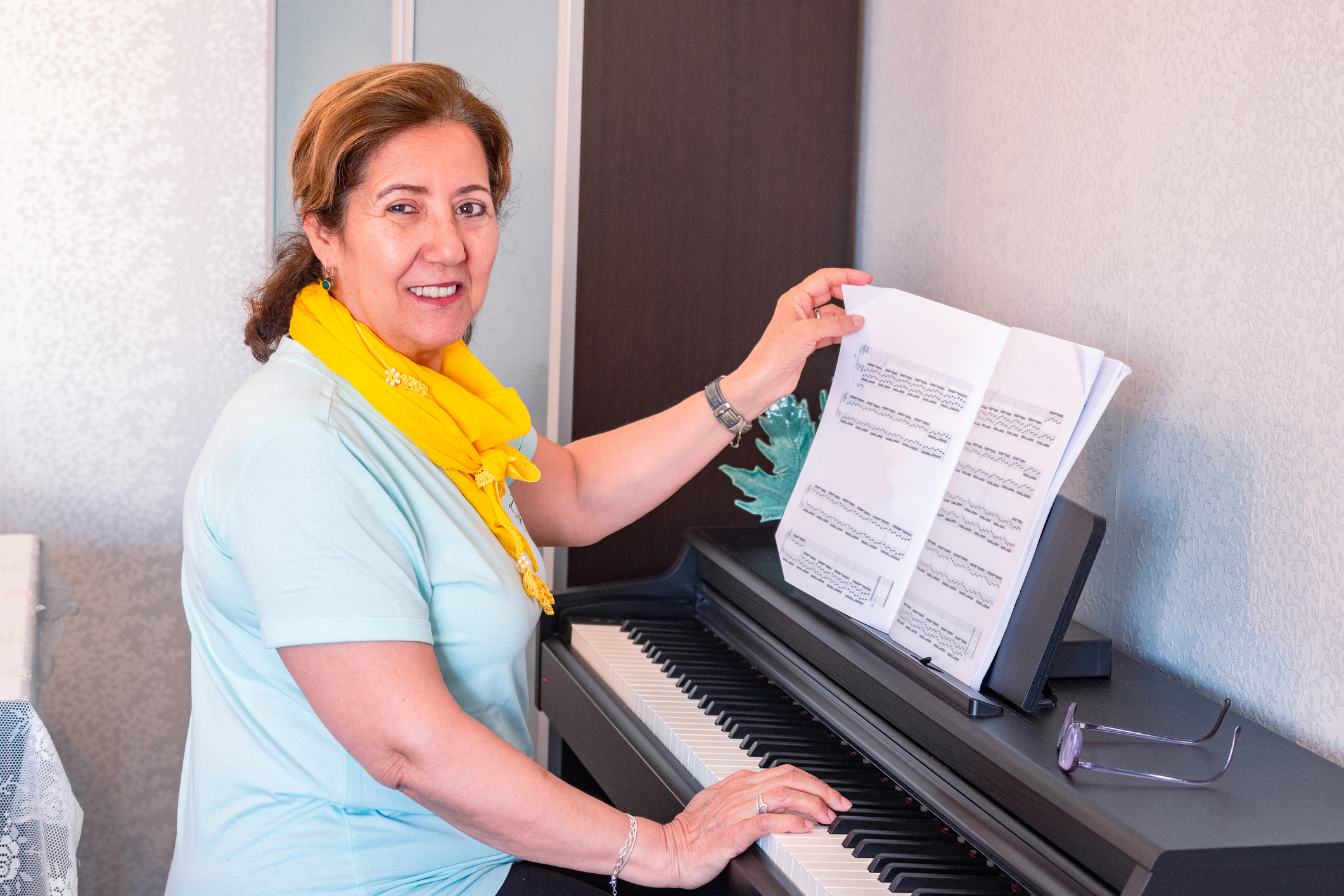 Adult piano student learning from structured sheet music through Piano Playing Made Simple online beginner piano lessons.